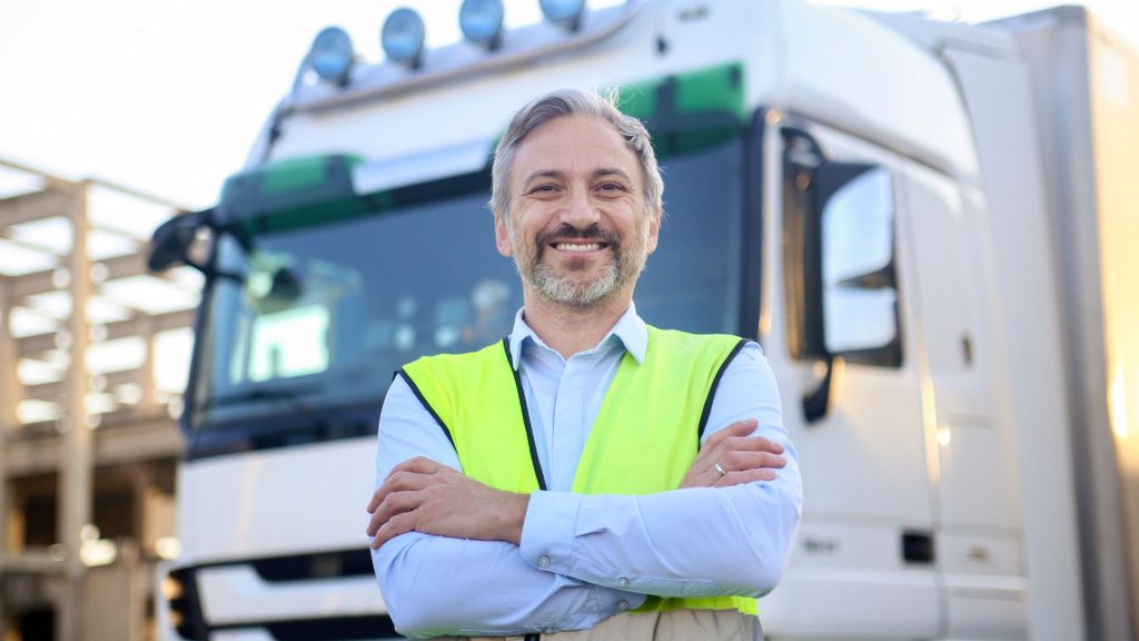 Chauffeur poids lourds devant son camion
